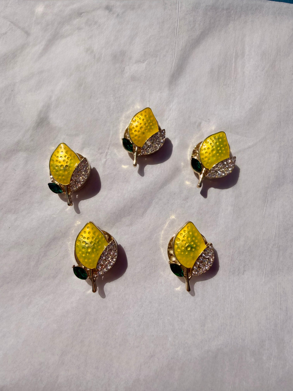 Dekorativ citronbroche med gul emalje og guldfinish