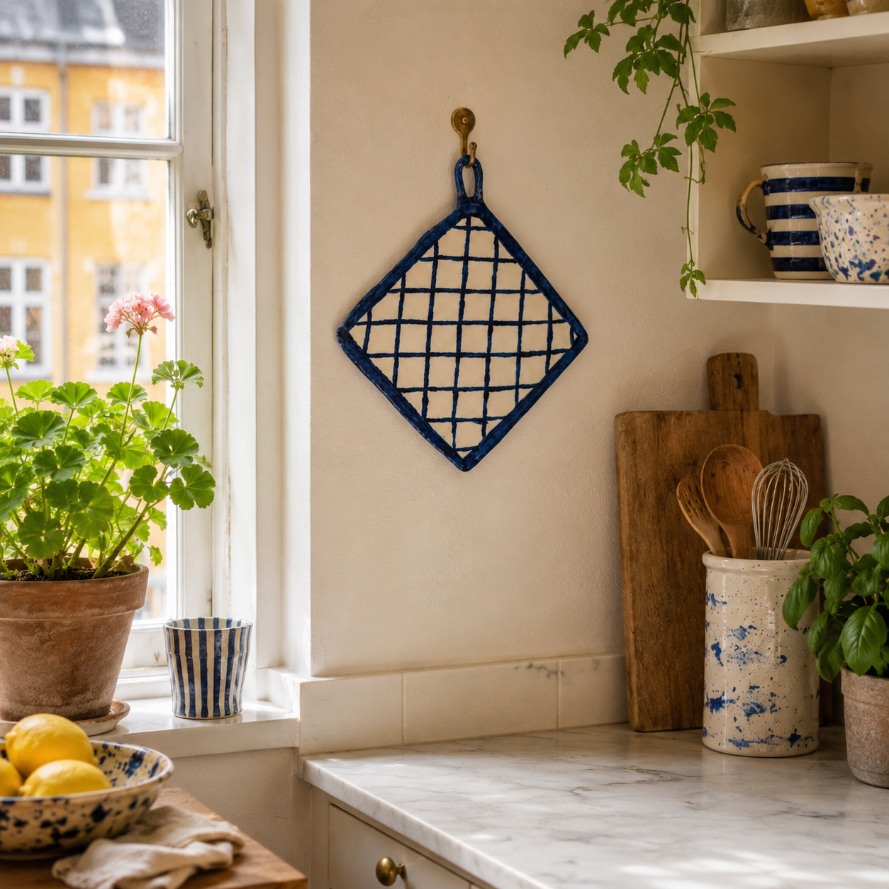 Den dekorative porcelænsgrydelap skaber et varmt og personligt udtryk i køkkenet.