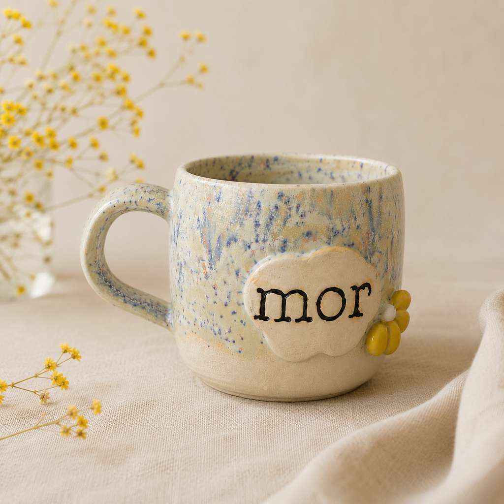 Detalje af den personlige “mor”-kop med organisk glasur og håndlavet blomsterdekoration.
