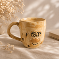 Detalje af koppen med teksten “far”, moustache og varm organisk glasur.