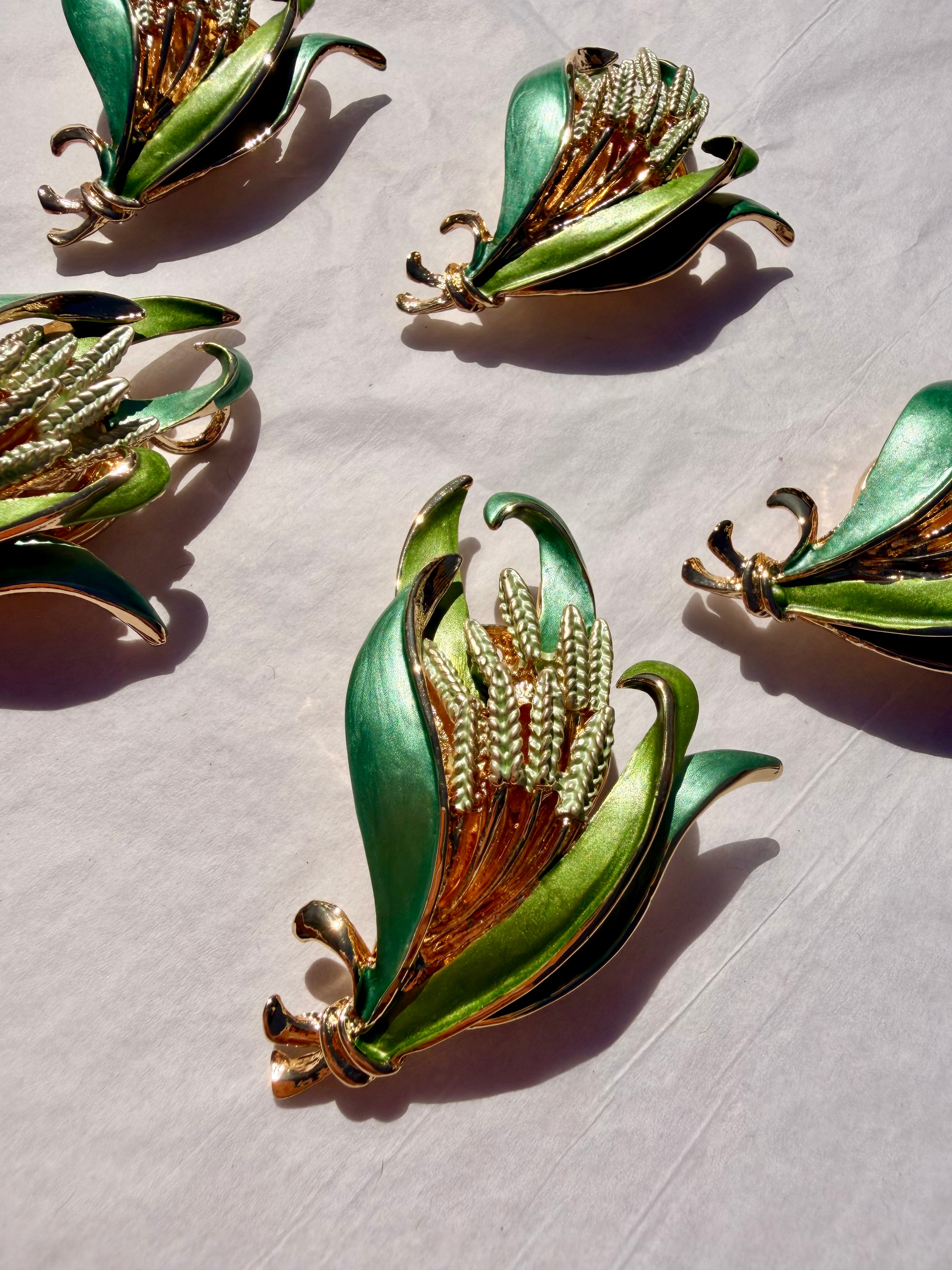 Detaljebillede af grøn blomsterbroche med guldfinish