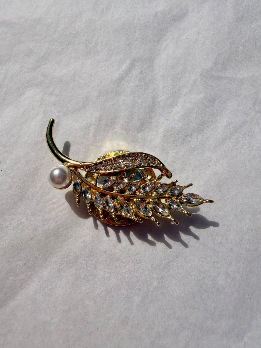 Elegant bladbroche med funklende krystaller og perledetalje