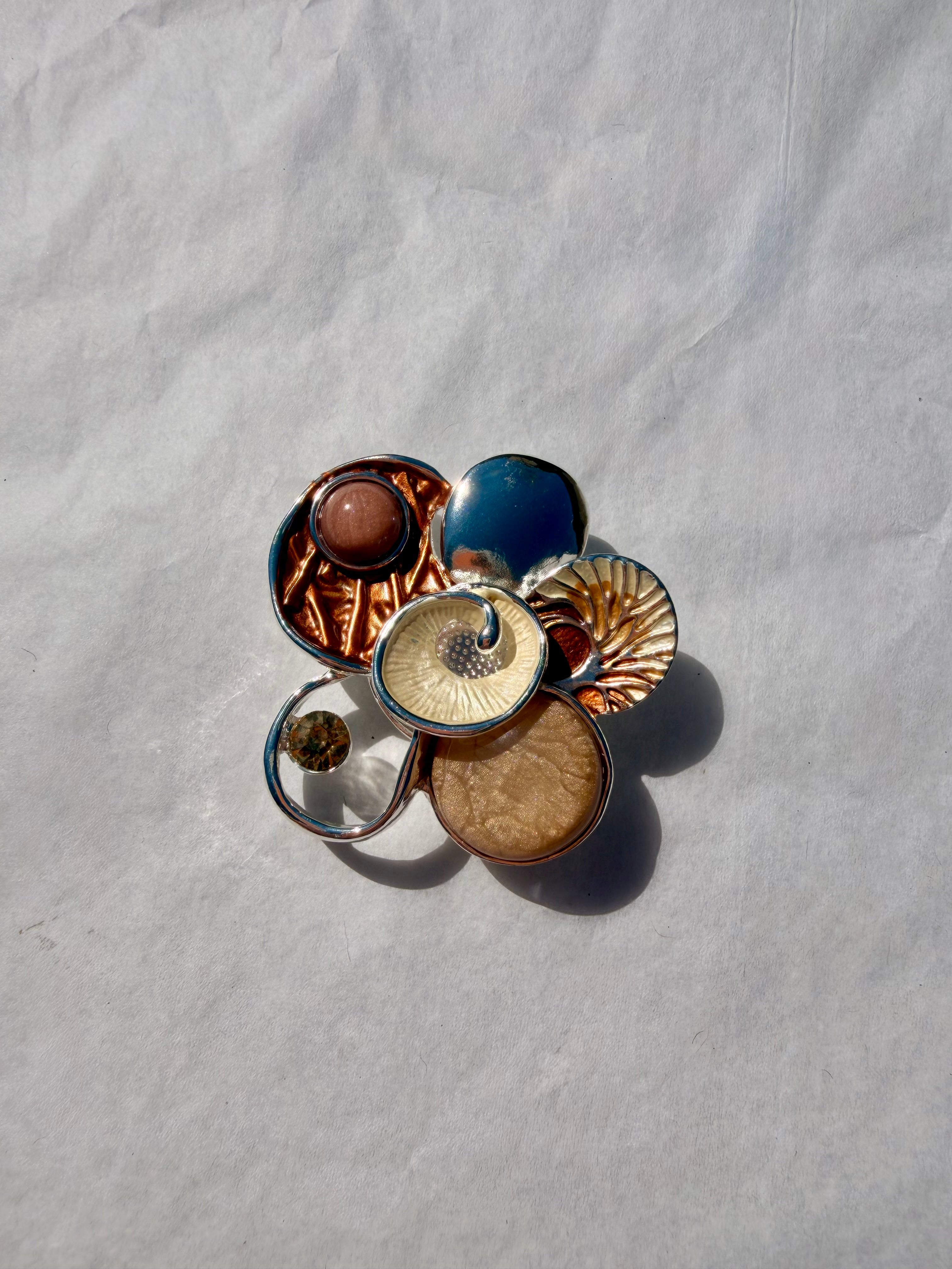 Elegant kunstbroche i beige og gyldne nuancer