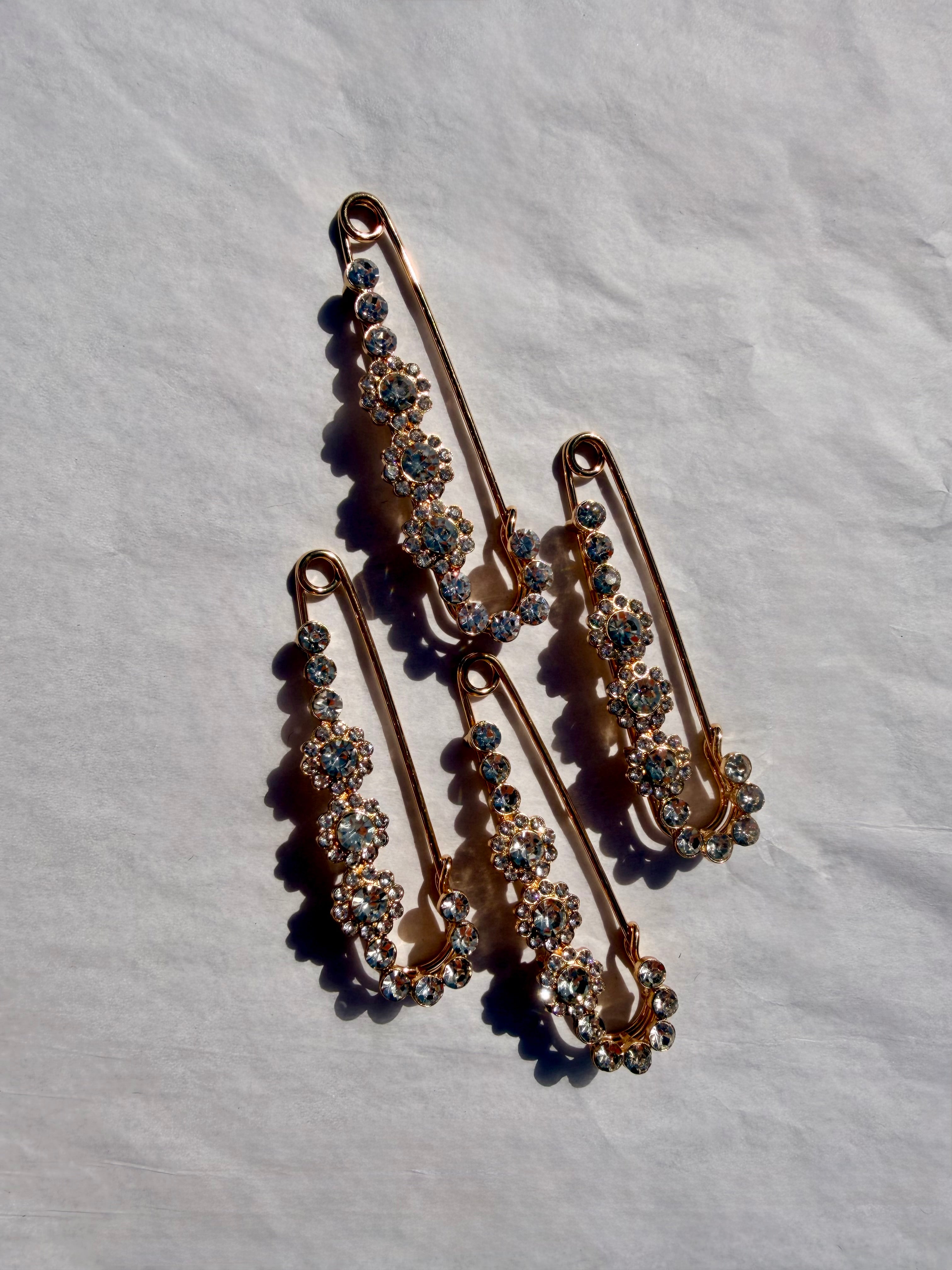 Elegant sjalsnål med funklende krystaller i guldfinish