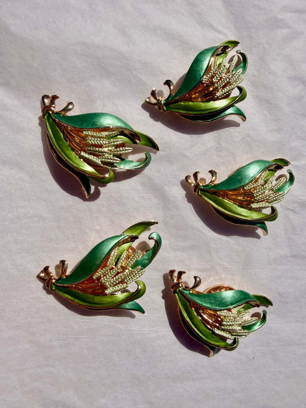 Grøn blomsterbroche med emaljedetaljer og elegant vintage design