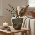 Skulpturel håndlavet vase stylet med tørrede pampasgræsser og eucalyptus i varmt nordisk interiør.