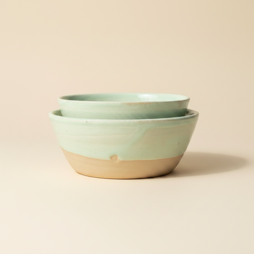 Stablede mintgrønne keramikskåle i minimalistisk studiostil.